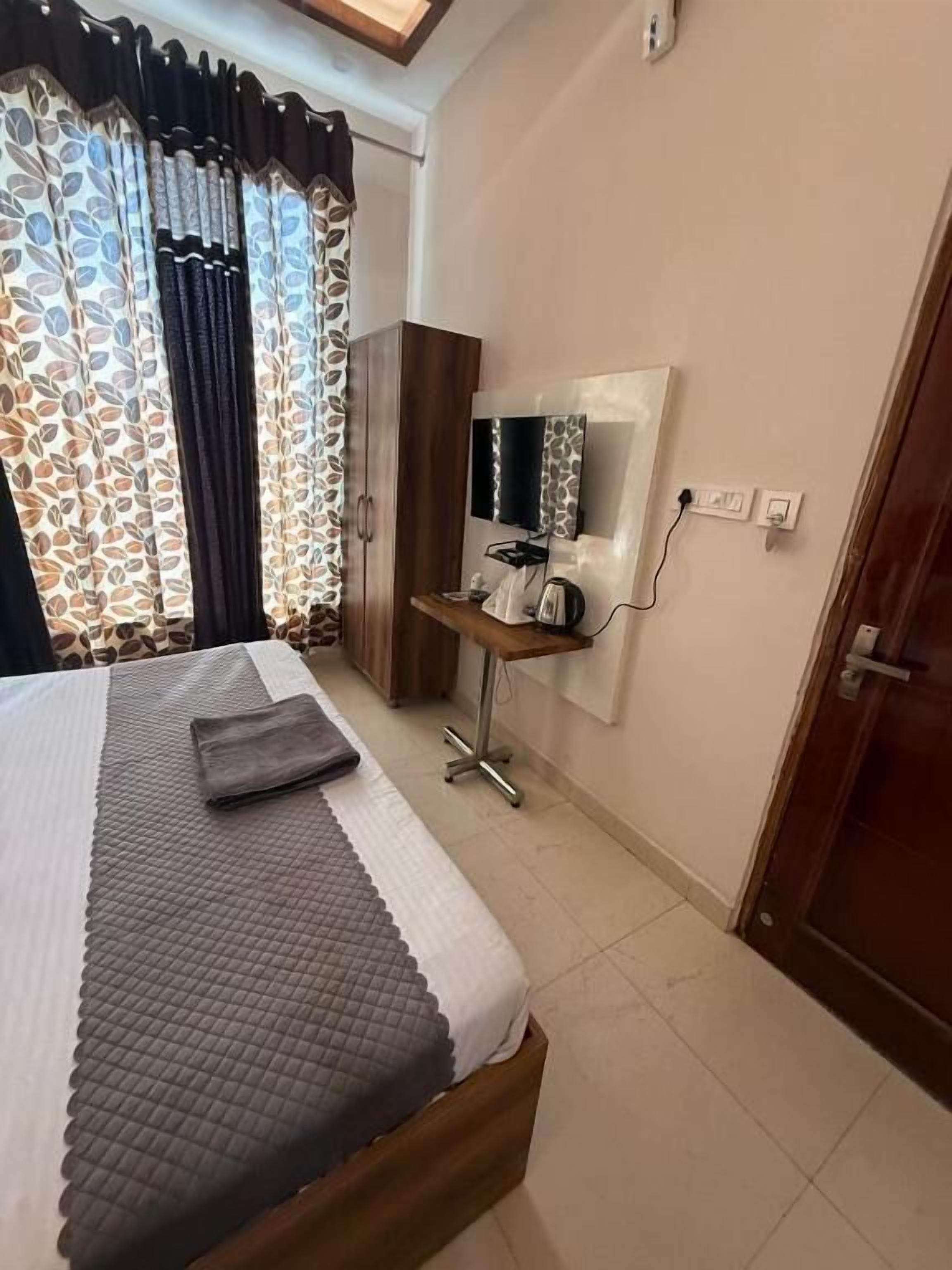 A bedroom with a bed, a desk with a mirror, and a wardrobe.