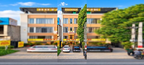 Un edificio de hotel con un cartel que dice 'HOTEL KARTIK' y una entrada visible.