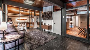 A modern living room with a large TV, a sofa, a coffee table, and a rug. - Luxury on Ocean Drive - Sleeps 28 (Corpus Christi)
