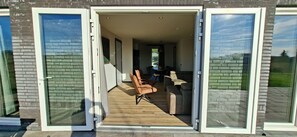 Une maison moderne dotée d’un grand patio ouvert, d’un coin repas avec une table et des chaises, et d’une cuisine à aire ouverte.