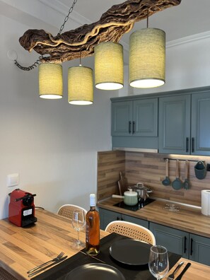 Un comedor con una mesa de madera, sillas y una lámpara colgante.