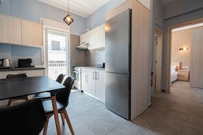 Eine moderne Küche mit Essbereich, einem Edelstahlkühlschrank und Blick ins Freie.