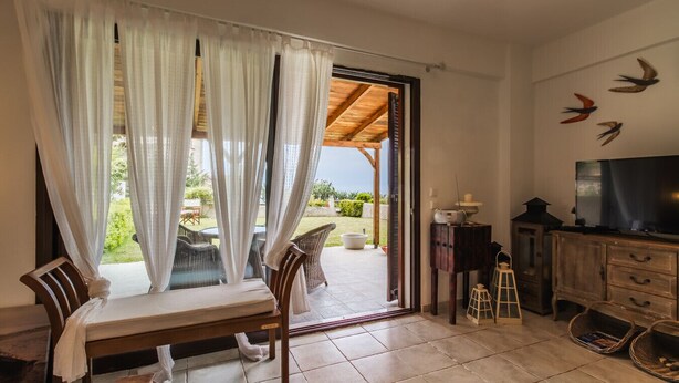 Una habitació amb taula de dinar, cadira, televisió i vista cap a l'exterior.