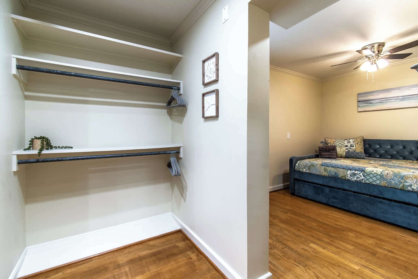 Ein Schlafzimmer mit einem Bett, einem Deckenventilator und einem Bild an der Wand.