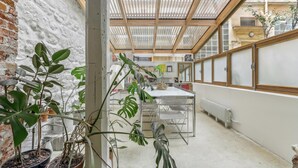 A narrow space with a table and chairs, potted plants, and a brick wall. - Apartment 'Loft Design Center Paris 11th' with Wi-Fi (Paris)