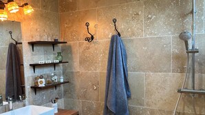 A bathroom with a sink, shelves, a towel rack, a shower, and a green mat. - Quiet room in a house between Mont Ventoux and dentelles de Montmirail (Saint-Hippolyte-le-Graveyron)