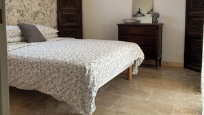 A bedroom with a bed, dresser, mirror, and wall-mounted light fixture. - Quiet room in a house between Mont Ventoux and dentelles de Montmirail (Saint-Hippolyte-le-Graveyron)