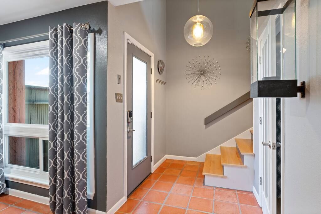 Uma escadaria com degraus de madeira e uma porta de vidro que dá para um quarto.