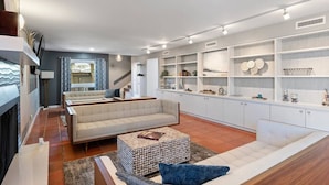 Un salon moderne comprenant un canapé, une table basse et des étagères intégrées ornées d’objets décoratifs.