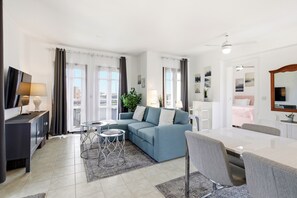 A modern living room with a sofa, coffee table, and dining table. - Beautiful Apartment Callysta PA11 (Kouklia)