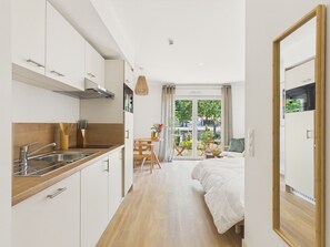 Eine moderne Küche mit weißen Schränken, einer Holz Arbeitsplatte und einem Edelstahl-Spülbecken.