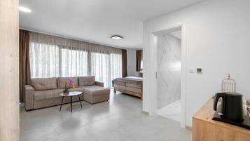 A modern living room with a sofa, a small table, and a bed.