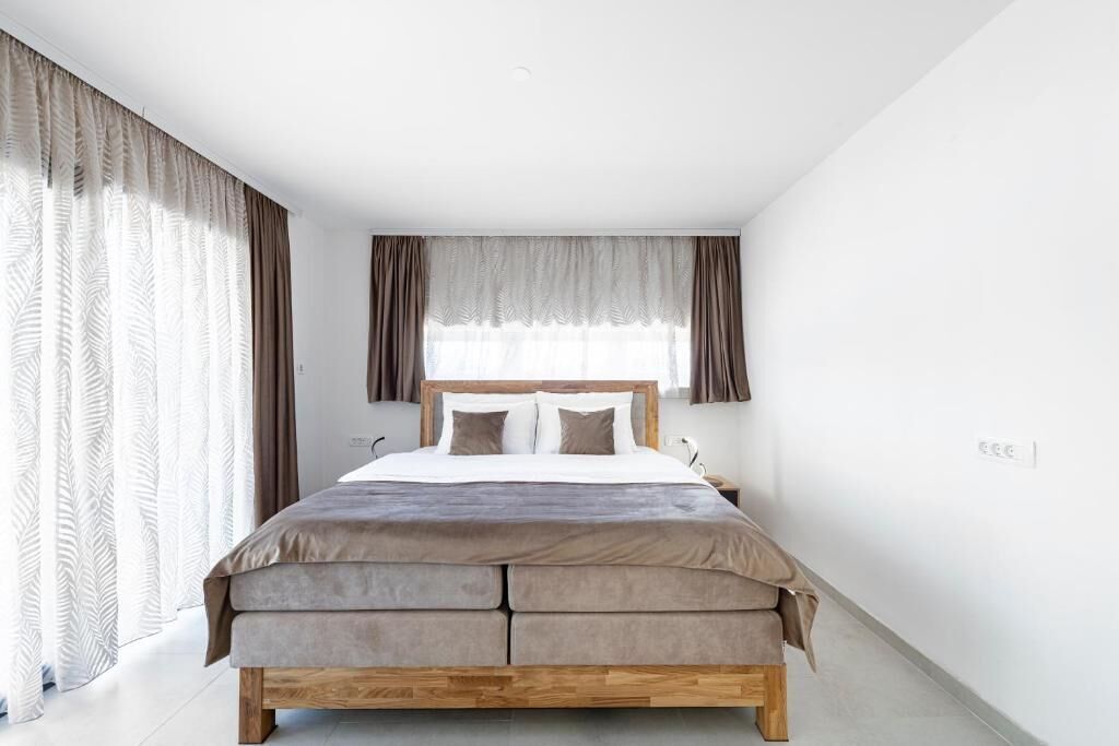 Un dormitorio con cama, cortinas y ventana.