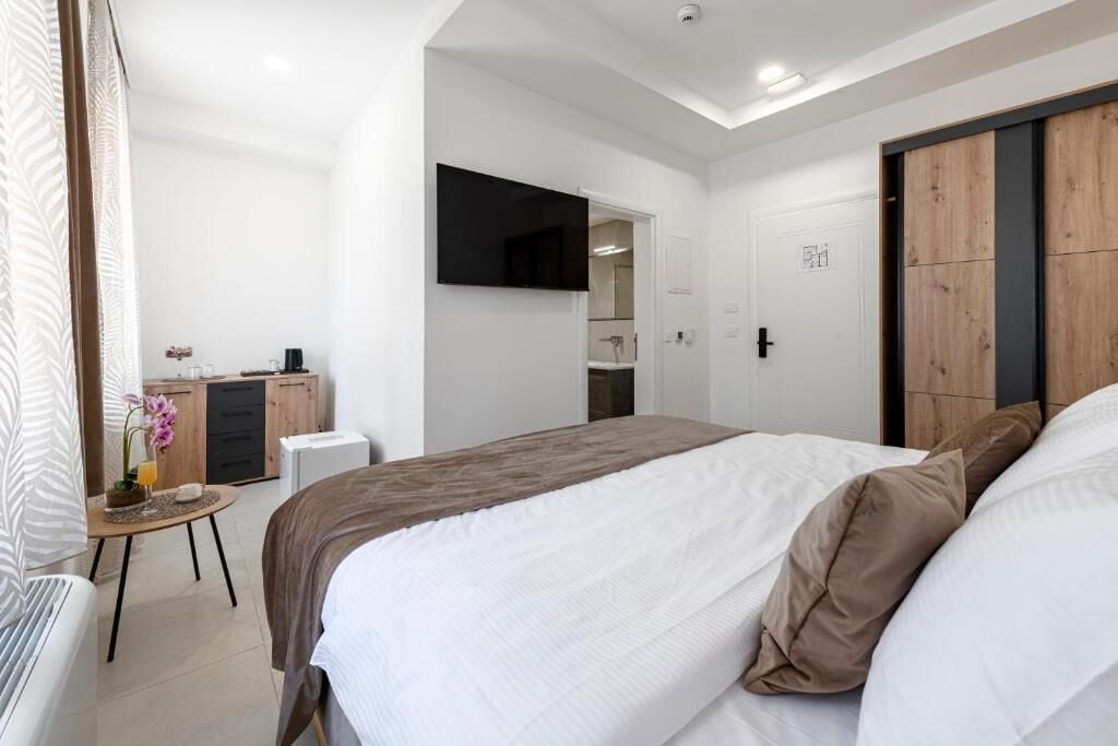 Quarto com cama, escrivaninha, espelho e guarda-roupa.