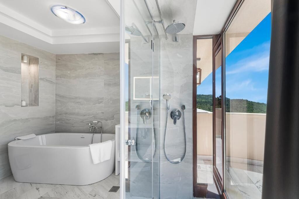 Un bagno moderno con vasca, doccia e cabina doccia in vetro.
