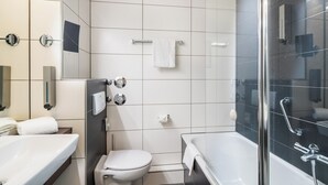 Et moderne badeværelse med badekar, toilet og håndvask.
