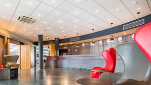 En rummelig lobby med en reception, moderne siddepladser og en skinnende marmorgulv.