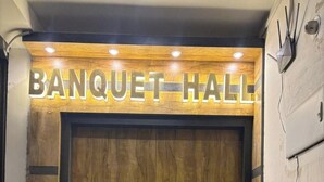 Una puerta de madera con un letrero que dice 'BANQUET HALL'.