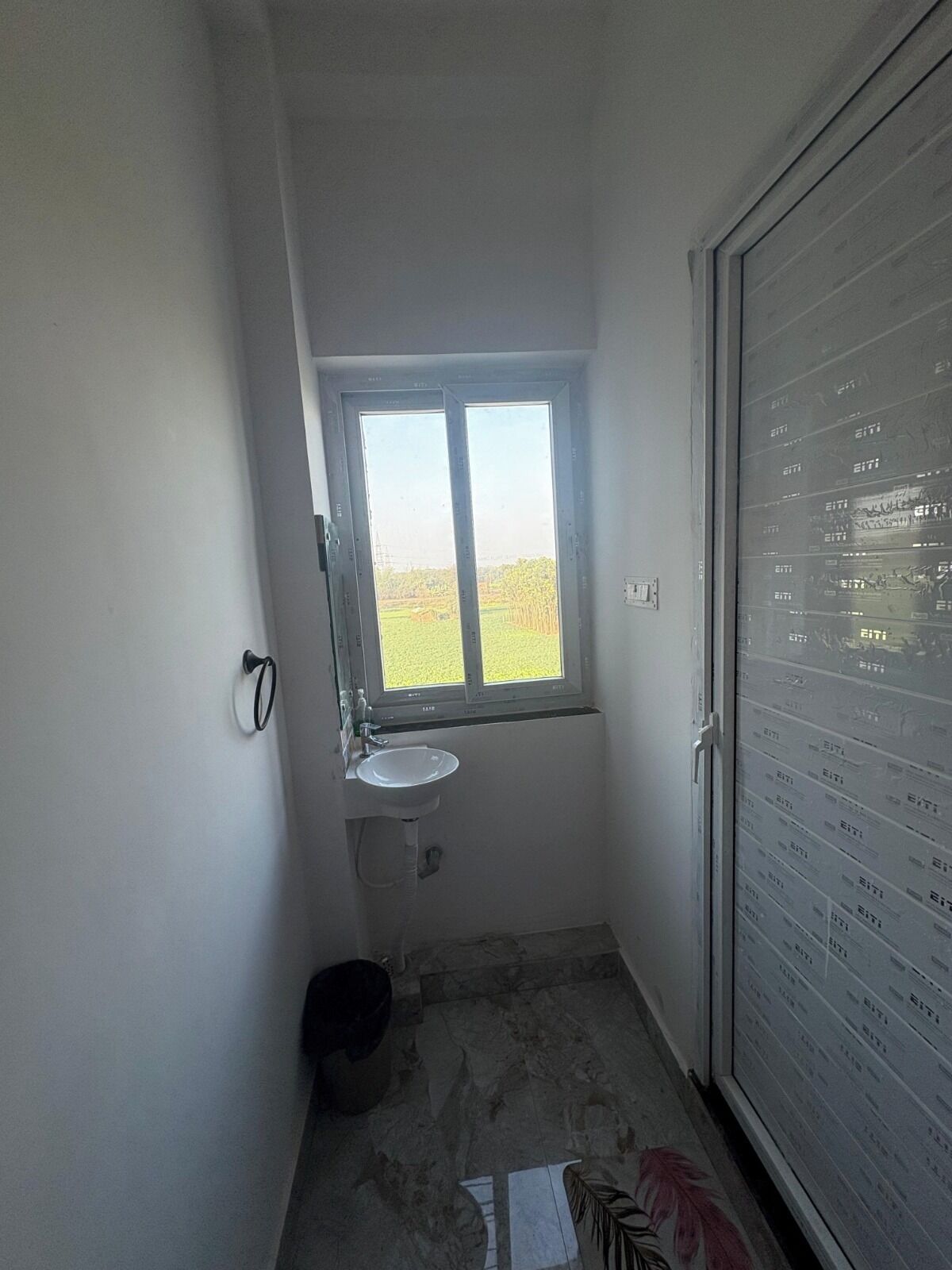 Uma casa de banho pequena com janela, lavatório e sanita.