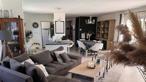 En moderne stue med sofa, sofabord og spiseplads.