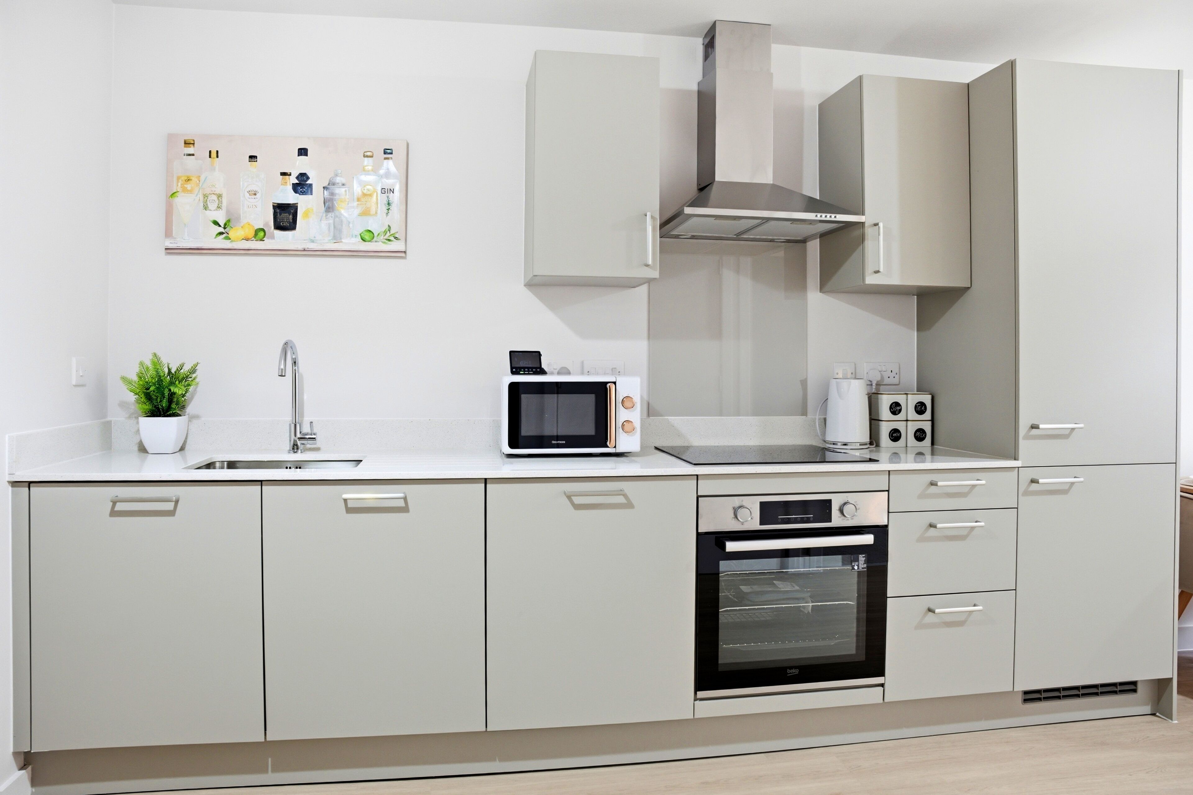 A modern kitchen with a microwave, oven, sink, and cabinet.