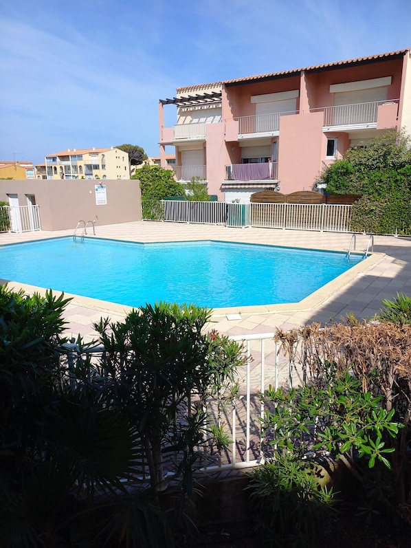 A rectangular swimming pool with a white pool ladder, surrounded by a white fence. - Bright cabin apartment for 4 people with a pool view (Agde)