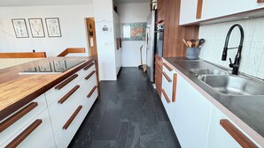 Una cucina moderna con mobili in legno, un lavello in acciaio inossidabile e un forno integrato.