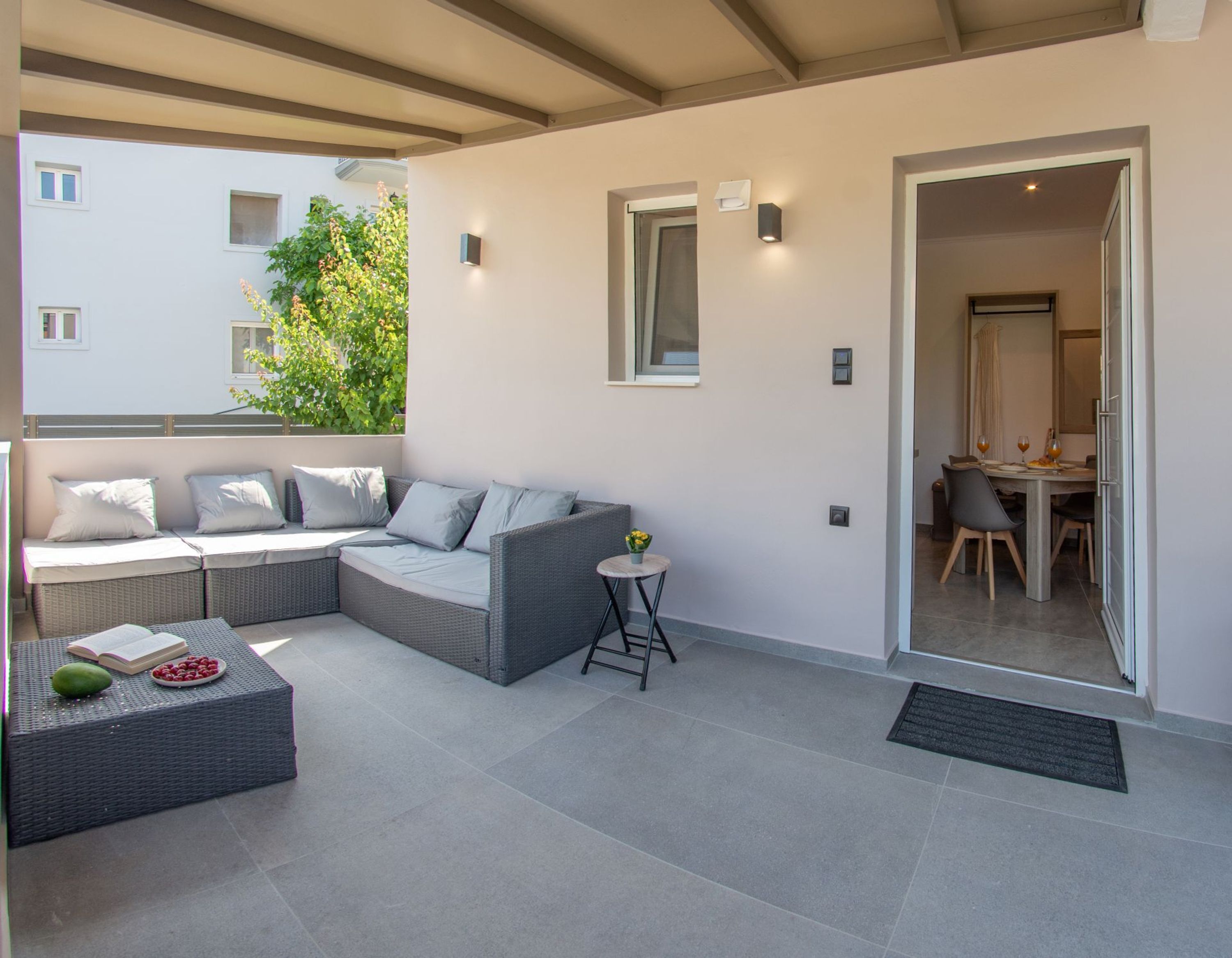 A modern living room with a sectional sofa, a small round table, and a dining area with a table and chairs.