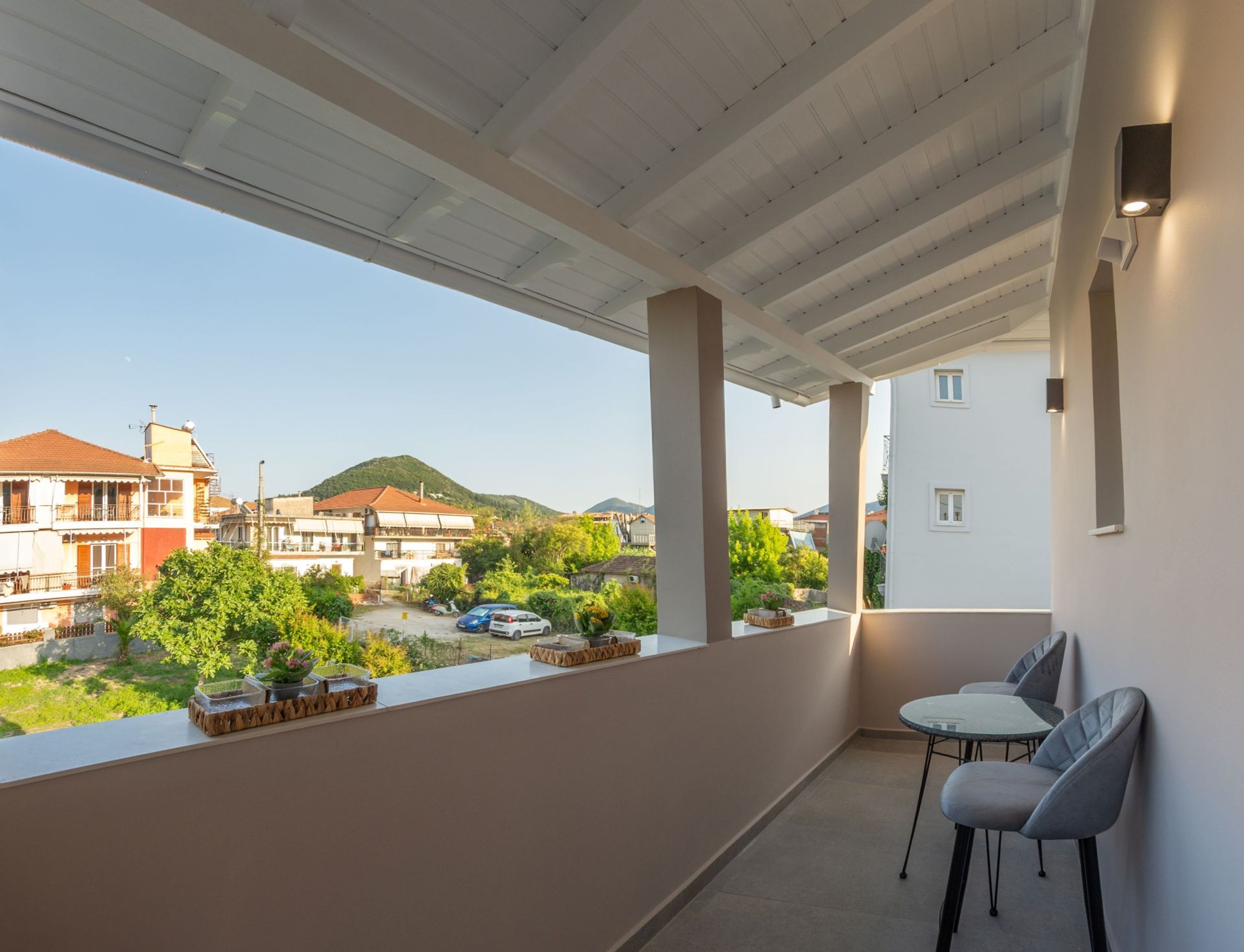 Un balcón con vista a un pueblo, una mesa y dos sillas.