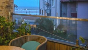 A room with a view of the sea, wicker furniture, and a wooden wall. - GGH Coastal Nest On The Beach (Brahmagiri)