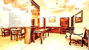 A room with wooden furniture, including a table and chairs, a sofa, and a cabinet. - Divine Heritage Hotel (Jaipur)