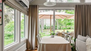 Zona pranzo con tavolo, sedie e vista sull'esterno.
