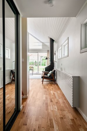 Ein modernes Interieur mit Holzboden, Kamin in Schwarz und Blick ins Freie.
