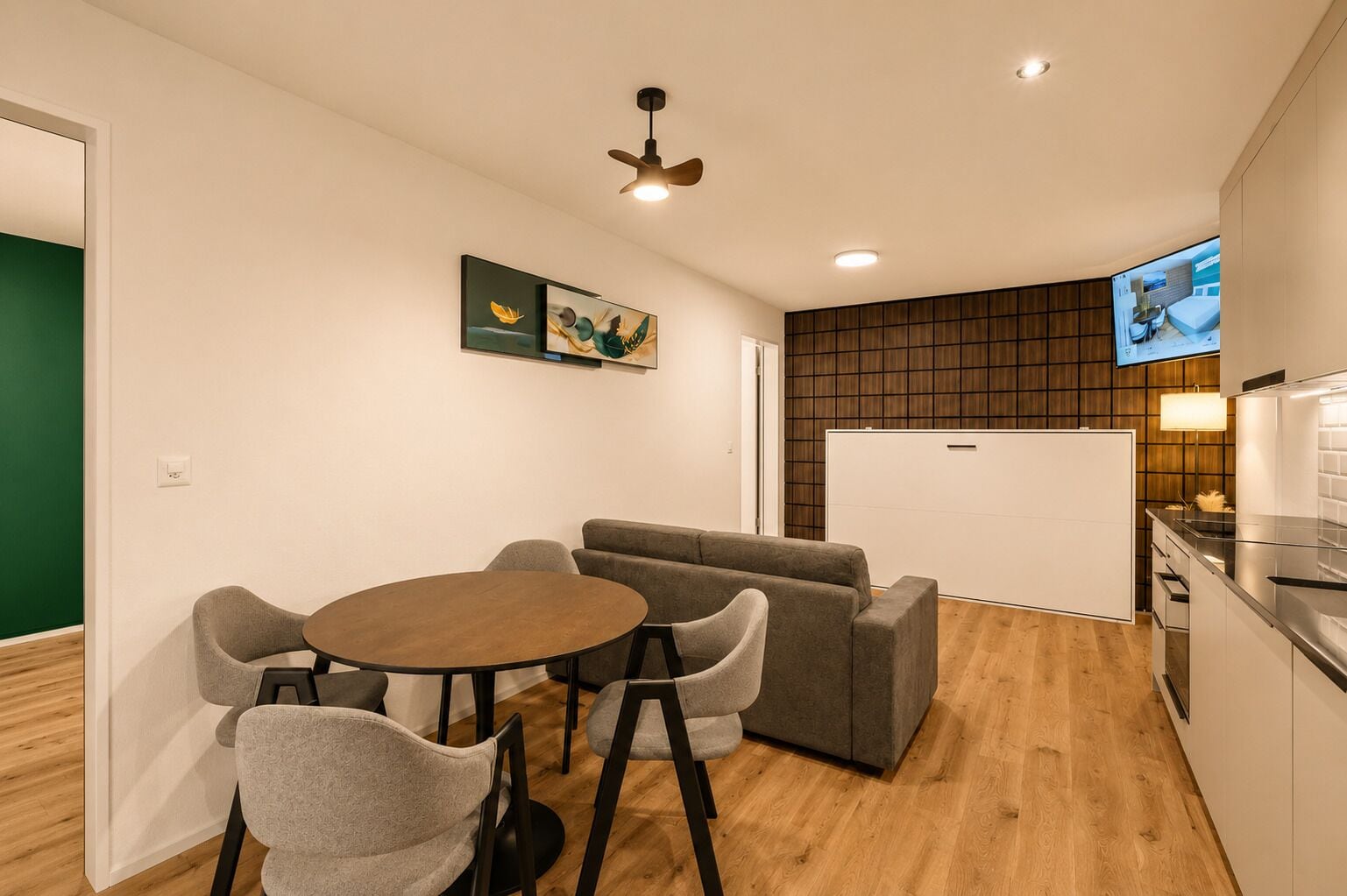Un espacio habitable compacto con comedor, sofá y kitchenette.