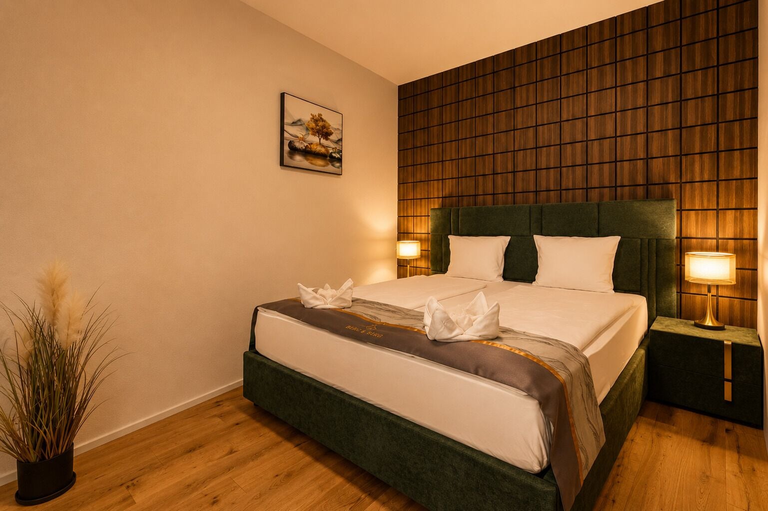 Ein Hotelzimmer mit einem Bett, Nachttischlampen, einem Wandbild und einer Topfpflanze.
