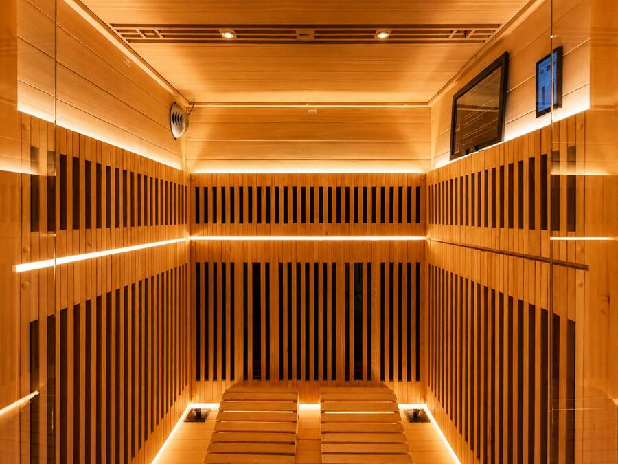 Een sauna met houten latten en een centrale bank.