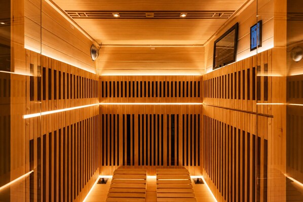 Una sauna con listones de madera y un banco central.