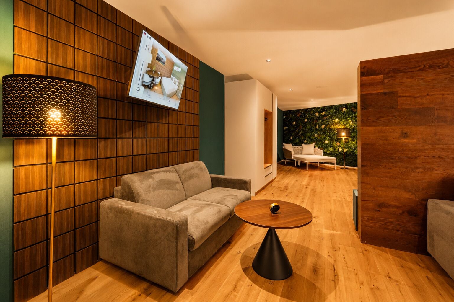 A modern living room with a sofa, a coffee table, and a wall-mounted TV.