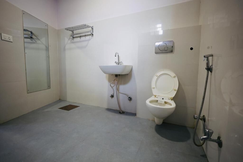 A bathroom with a toilet, sink, and shower.