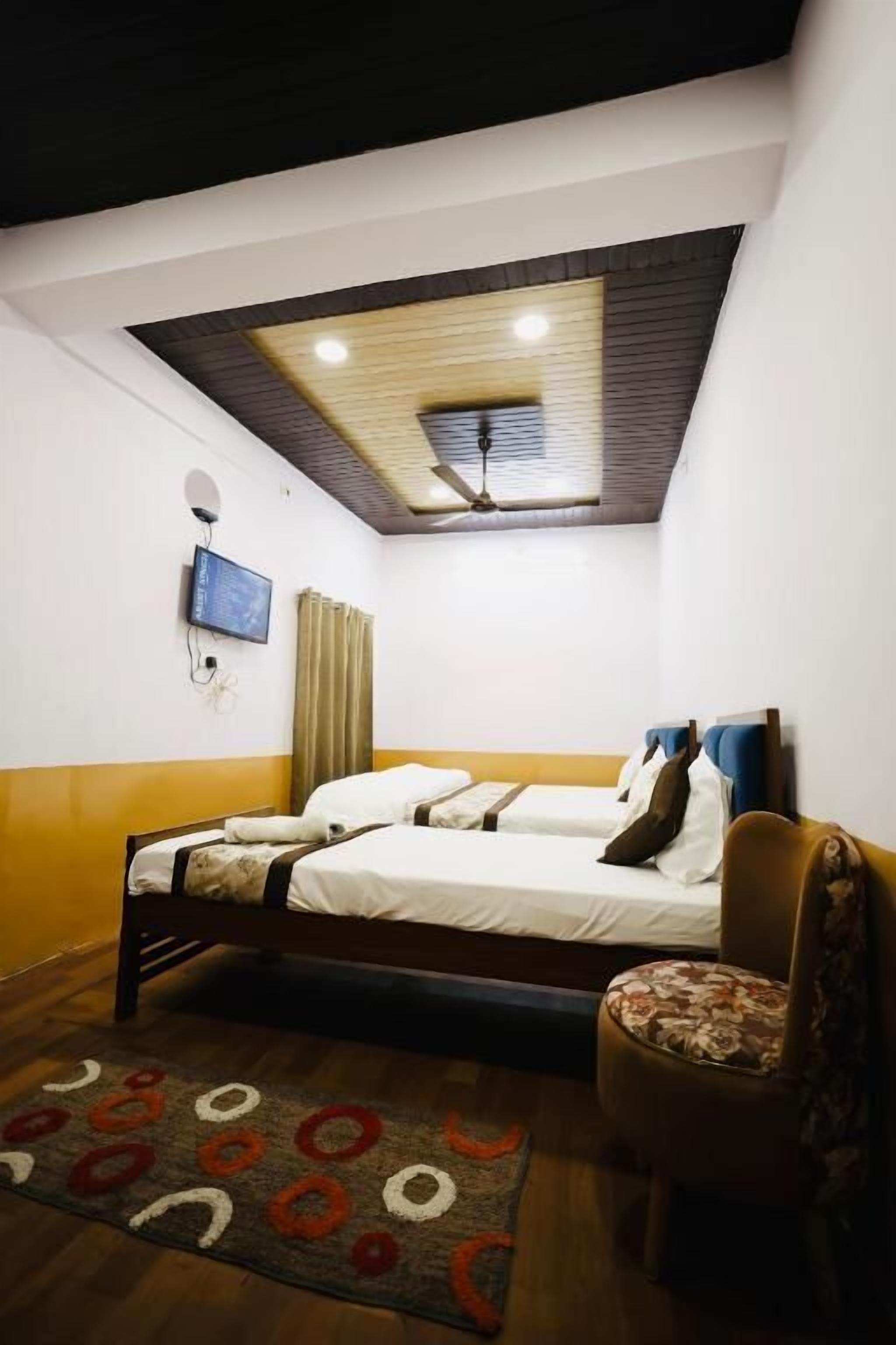 Een slaapkamer met een bed, een stoel, een televisie en een plafondventilator.