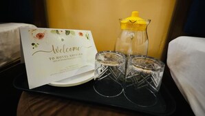 A welcome sign, a glass pitcher, and two glasses on a tray. - Hotel Shivika (Bikaner)