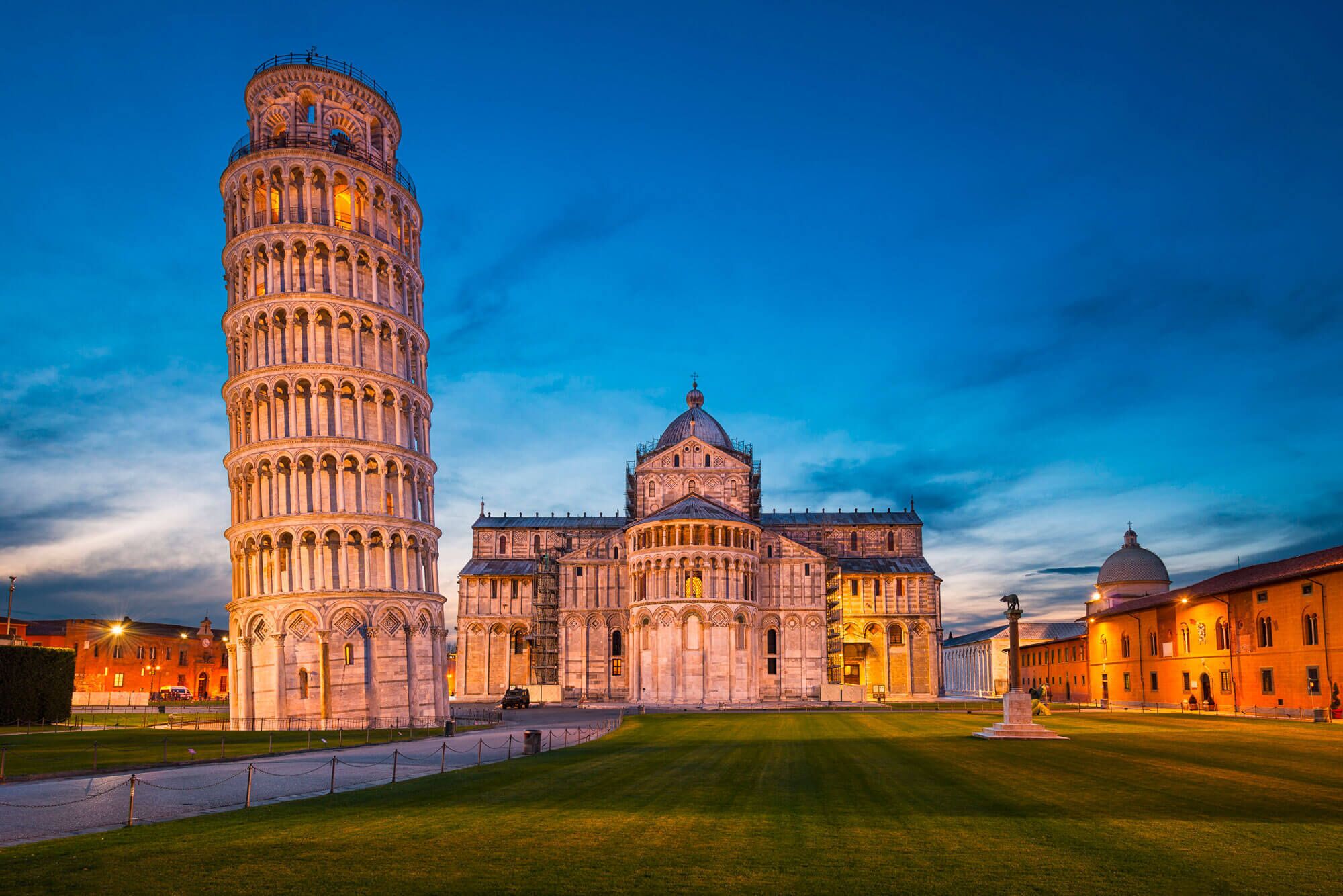 The Leaning Tower of Pisa and the Pisa Cathedral with a clear view of the surrounding grassy area.