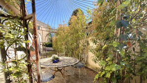 A round metal table with two chairs, surrounded by greenery and a metal trellis. - Charming Tuscan Home - Near Pisa, Volterra & Wine Tours (Capannoli)