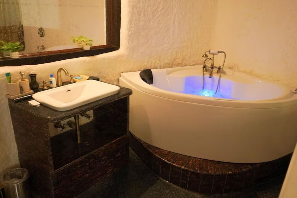 A bathroom with a white bathtub, a sink, and a mirror.