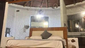 A circular wooden bed with a headboard, a ceiling fan, and a large mirror on the wall. - Corbett Cabana Farm (Haldwani)