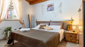 A bedroom with a bed, bedside table, lamp, and a painting on the wall. - Casa Villa Aury — Cefalù, green oasis steps from the sea (Cefalù)