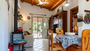 A cozy dining area with a wooden table, chairs, and a patterned tablecloth. - Casa Villa Aury — Cefalù, green oasis steps from the sea (Cefalù)