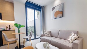 A modern living room with a sofa, coffee table, and chairs. - Maison Solférino  (Boulogne-Billancourt)