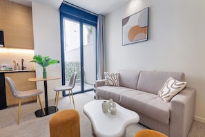 Un salon moderne avec un canapé, une table basse et des fauteuils.