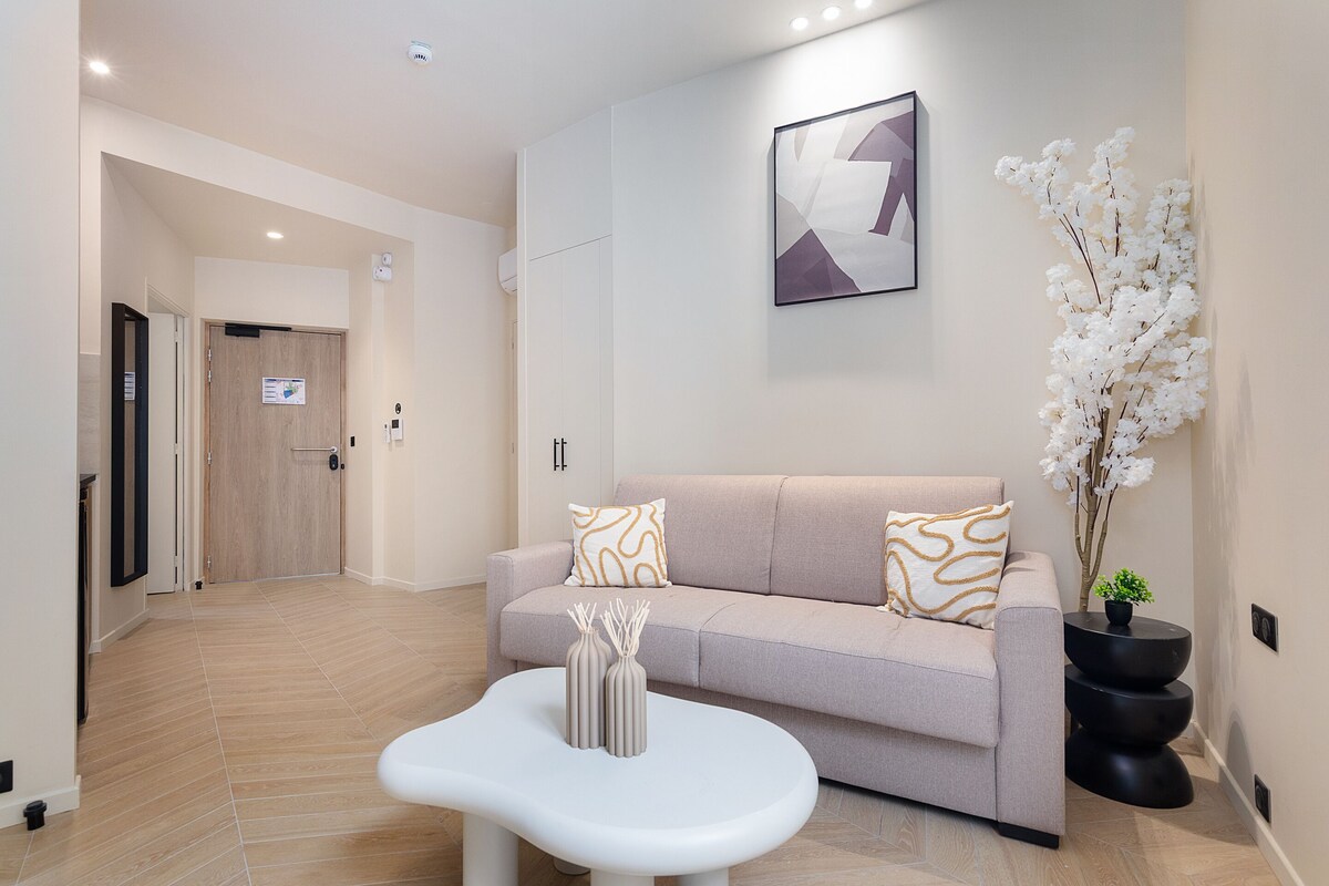 Una sala de estar moderna con un sofá, una mesa de centro y una planta en maceta.